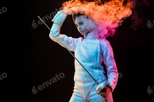 Preview: Teen girl in fencing costume with sword in hand isolated on black background