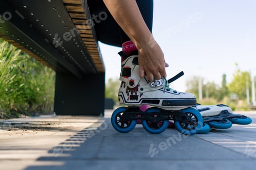 Preview: girl puts on roller skates in skate park before starting skating street extreme sport