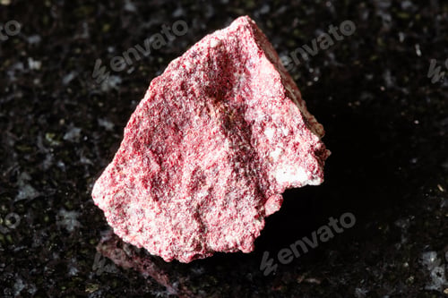 Preview: sample of raw cinnabar mineral on black granite