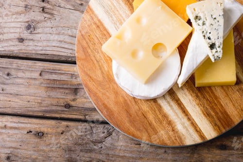 Preview: Directly above shot of various cheese on wooden board at table, copy space
