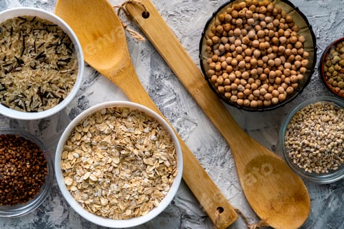 Preview: selection of raw uncooked cereals grains in bulbs with chickpeas oat lentil rice buckwheats