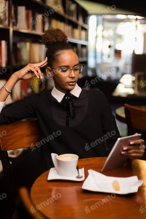 Preview: Young Woman Working on Tablet in Coffee Shop