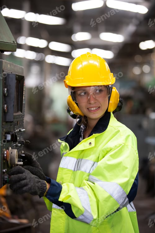 Preview: Woman worker wearing safety goggles control lathe machine to drill components. Metal lathe industria
