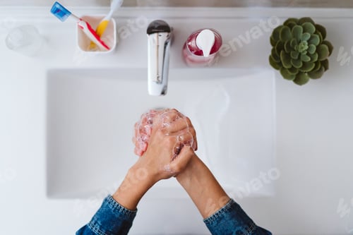 Preview: unrecognizable woman washing hands on a sink with soap. Coronavirus covid-19 concept