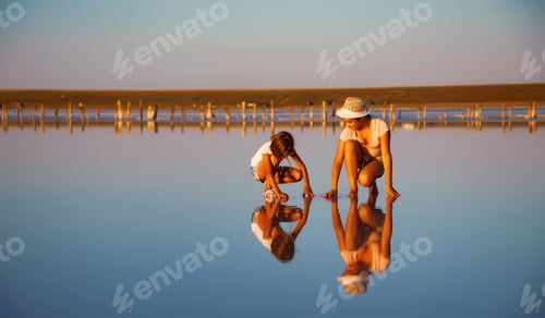 Preview: Two fantastically beautiful girls on a beautiful transparent lake are looking for something in a