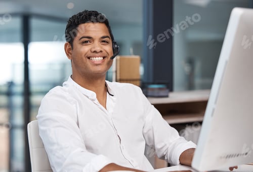 Preview: Portrait of a young businessman working on a computer in a call centre