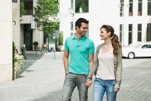 Preview: Germany, Berlin, Couple walking hand in hand through city street