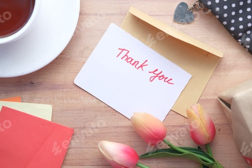 Preview: thank you message and envelope on wooden table