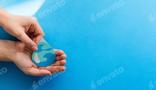 Preview: View of woman hands holding paper cut water drop on a blue background - World Water Day