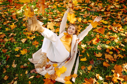 Preview: ?appy young woman having fun with leaves in autumn park.