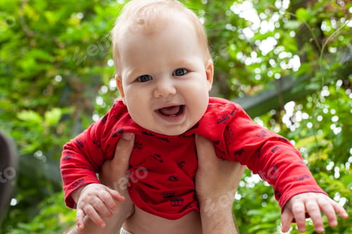 Preview: the little baby was lifted up in his arms, the baby smiles and laughs.