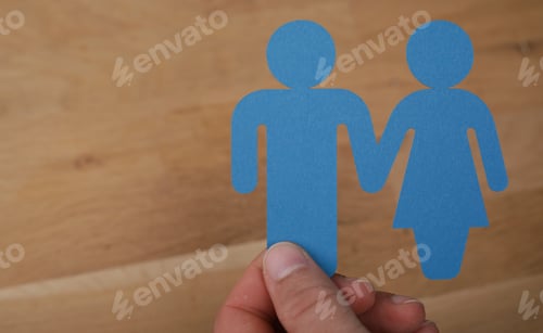 Preview: Closeup shot of a man holding blue female and male signs on a wooden background