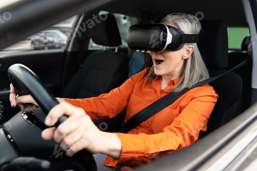 Preview: Senior woman wearing virtual reality glasses, driving car. Innovation concept
