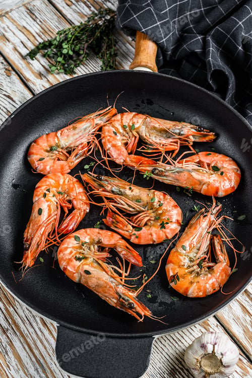 Preview: Fried giant tiger shrimps Prawns in a pan. White wooden background. Top view