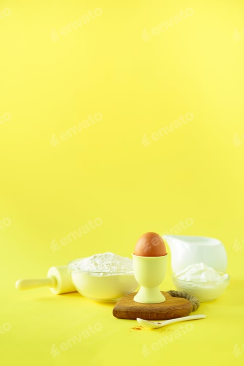 Preview: Healthy baking ingredients - butter, sugar, flour, eggs, oil, spoon, brush, whisk, milk over yellow