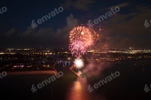Visualização: Vista aérea de fogos de artifício brilhantes explodindo com luzes coloridas sobre a costa do mar