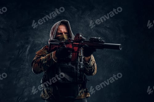 Preview: Special forces soldier wearing body armor holding an assault rifle. Studio photo