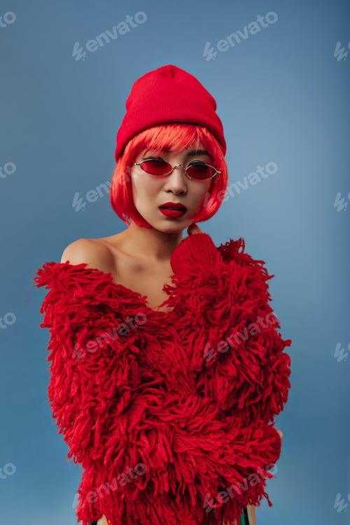 Preview: Beautiful cool lady with short hair and red lips in warm long sleeve sweater and cool cap looking i