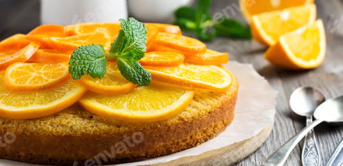 Preview: Orange and mandarin cake with polenta, upside down on the old wooden background. Selective focus.
