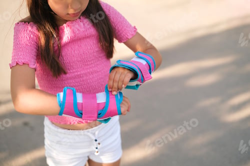Preview: Girl is preparing for roller skating, wearing protective gloves
