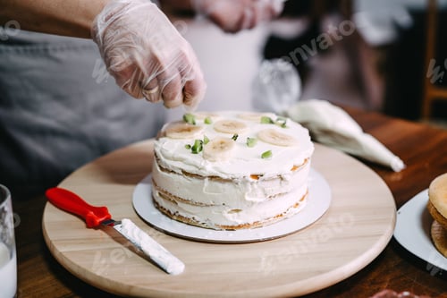 Preview: Making cakes and desserts at home. A woman in disposable gloves and an apron cooks a cake.