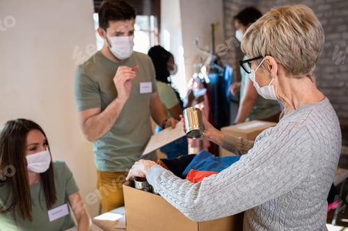Preview: Group of volunteers with working in community charity donation center.