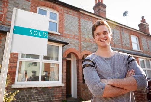 Preview: Portrait Of Excited Man Standing Outside New Home With Sold Sign