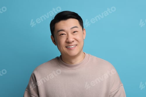 Preview: Portrait of happy man on light blue background