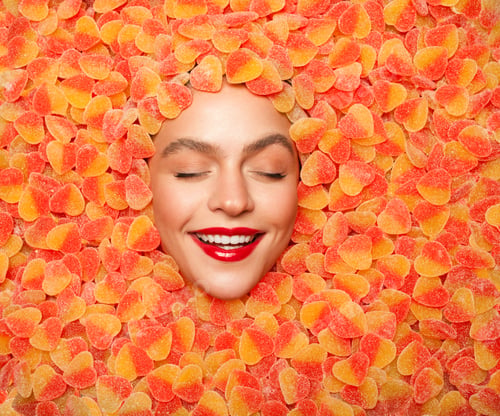 Preview: Delighted female resting in fruit jelly candies