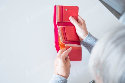Preview: close up of hands of mature woman looking and revising how many money she have in her wallet