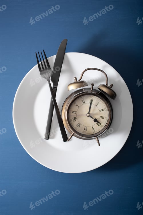 Preview: concept of intermittent fasting, ketogenic diet, weight loss. alarmclock fork and knife on a plate