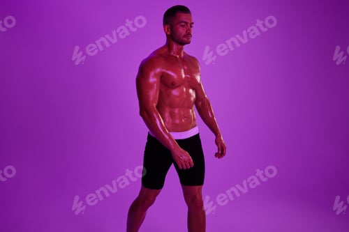 Preview: Man athletic bodybuilder poses with nude torso abs in full-length background, boxing and martial