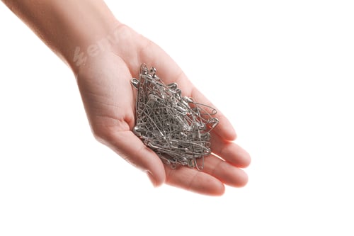 Preview: Woman holding pile of safety pins on white background, closeup
