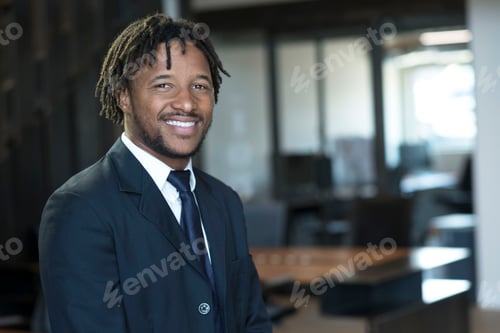 Preview: Portrait of young businessman in office, smiling