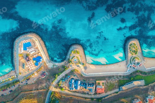 Preview: Aerial view of sandy beach, blue sea, restaurants at sunset