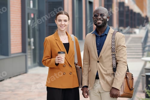 Preview: Two young successful brokers in quiet luxury apparel looking at camera