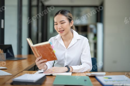 Preview: Young Woman Enjoying Book in Modern Office Environment