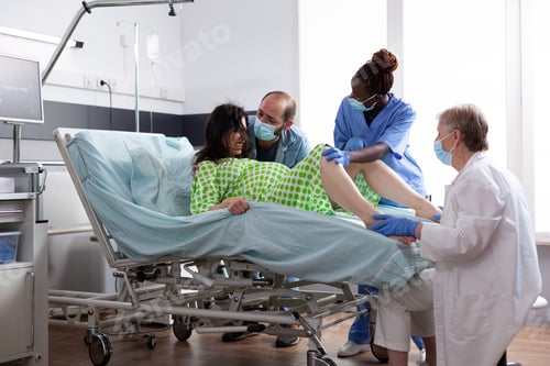 Preview: Multi ethnic medical team helping with child delivery