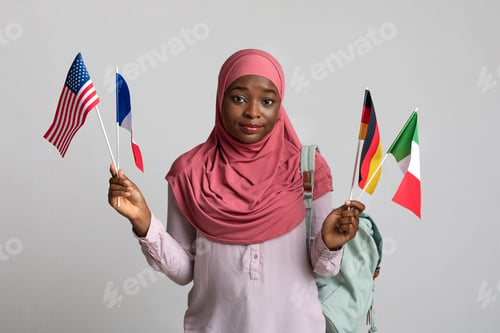 Preview: Confused african american woman in hijab showing diverse flags