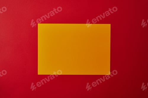 Preview: top view of blank yellow paper on red surface