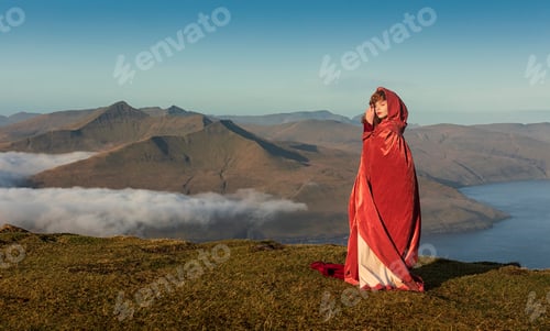 Preview: A woman in old-fashioned clothes with a bright red cloak. Faroe Islands, Denmark