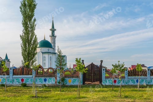 Preview: Muslim mosque with minaret and madrasah against blue cloudy summer sky