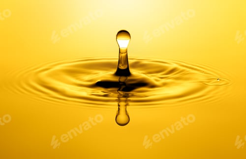 Vista previa: Yellow drop falling creating a splash of oil or water background. Olive, sunflower, cosmetic oil