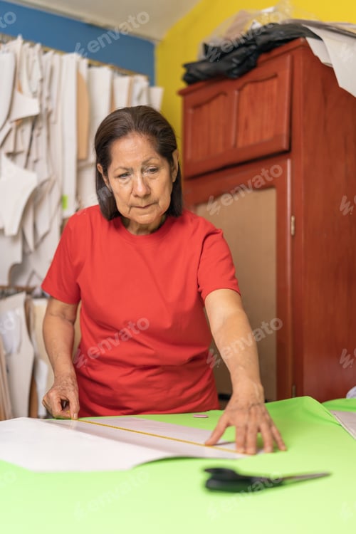 Preview: Woman measuring a fabric on a cutting table in a sewing shop