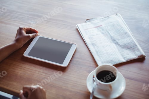 Preview: Hands of woman using digital tablet while having coffee