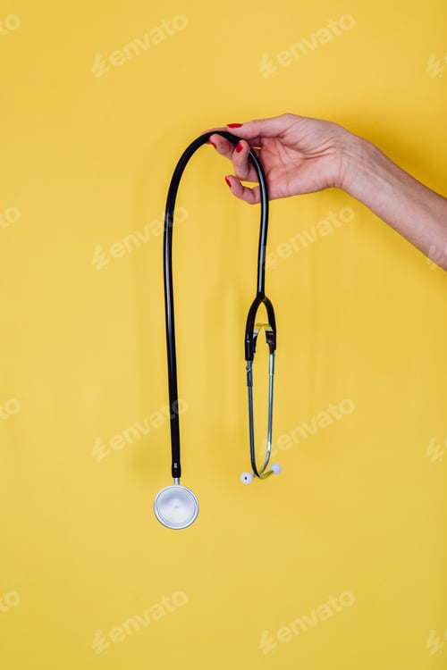 Preview: Doctor holding a stethoscope on a yellow background