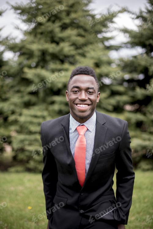 Preview: Vertical shot of a well-dressed male while smiling at the camera