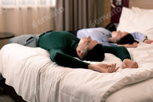 Preview: young couple in the room of a luxury hotel room lovers fall on the bed raise their hands to the top