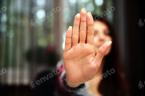 Preview: Woman With Her Hand Extended Signaling To Stop (Only Her Hand Is In Focus)