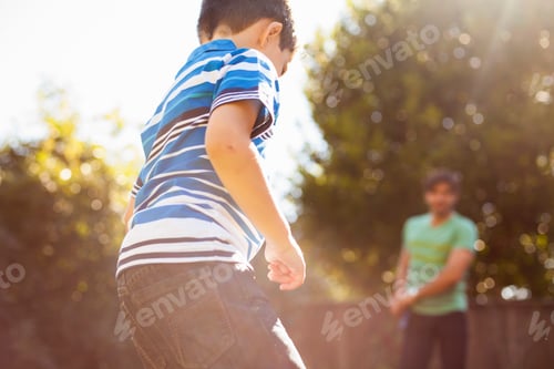 Preview: Father and son playing football in garden